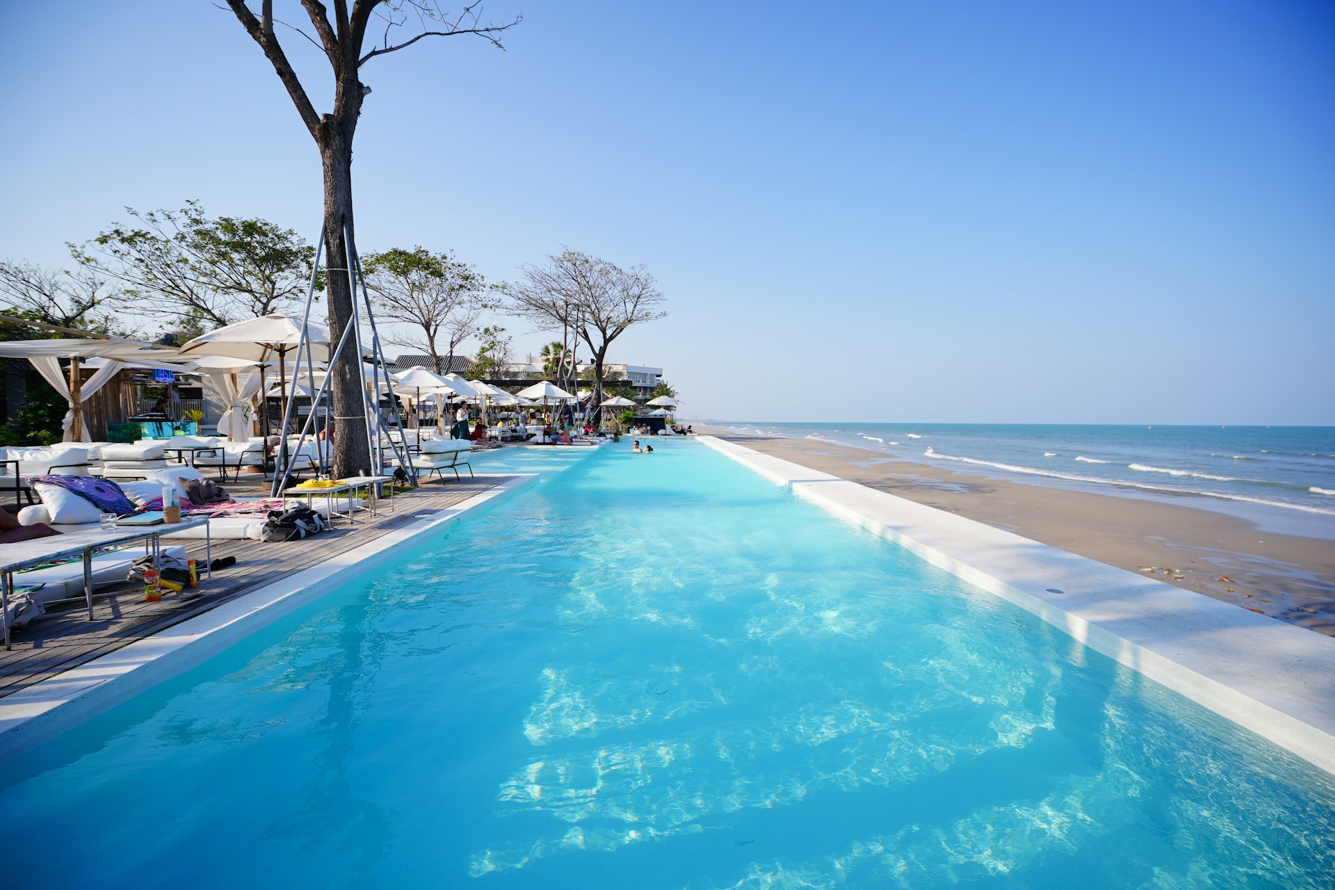 A concrete pool deck leading straight onto the beach